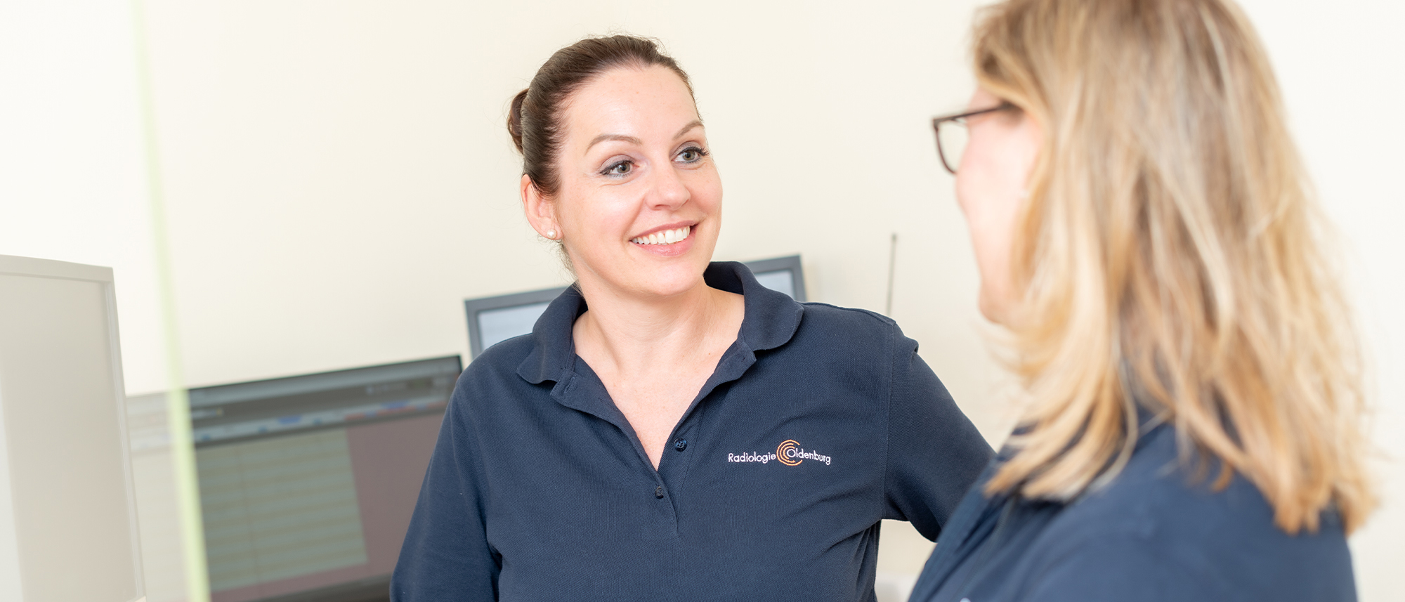 Zwei Medizinische Fachangestellte der Radiologie Oldenburg unterhalten sich im Untersuchungsraum.